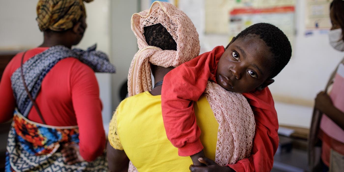 Mutter mit Kind in einem Gesundheitszentrum nahe eines Umsiedlungsdorfes in Cabo Delgado.